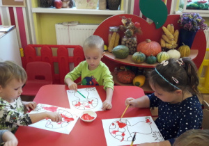 Dzieci malują farbami kolorowankę "Muchomor"